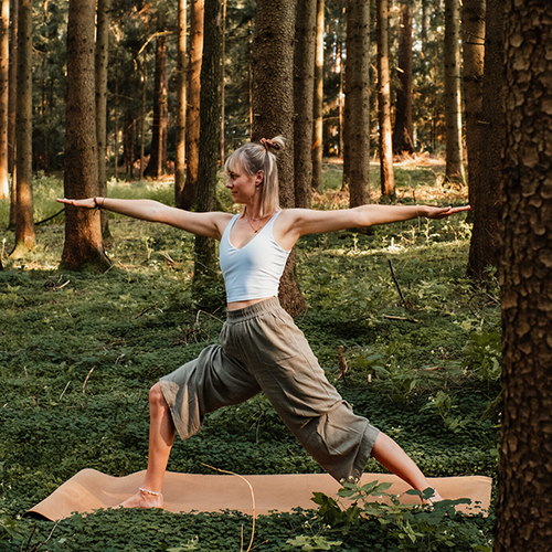 Frau macht Yoga im Wald